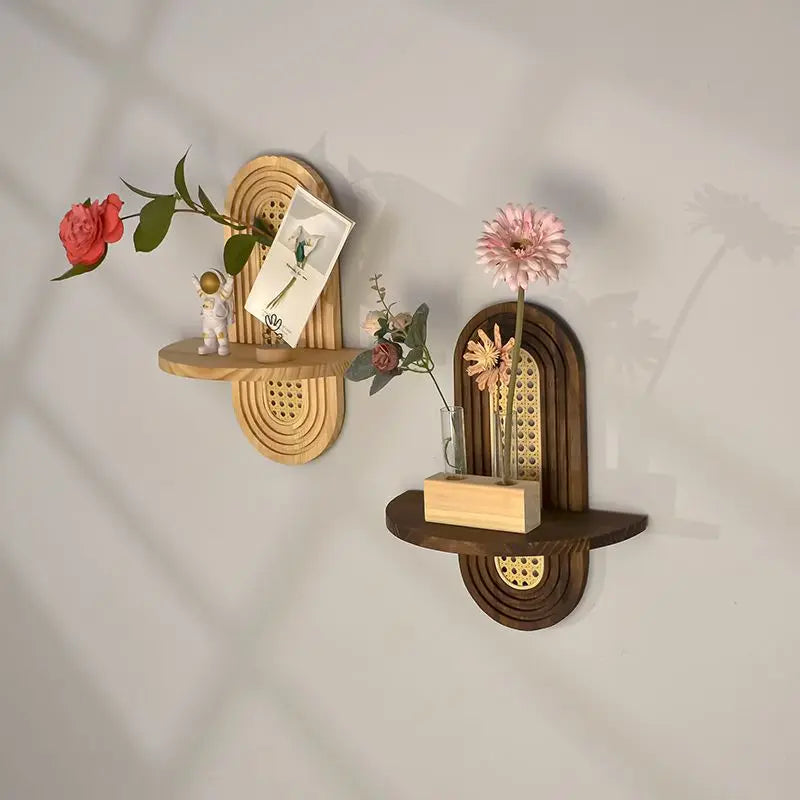 Two decorative wall shelves with floral arrangements on a plain background